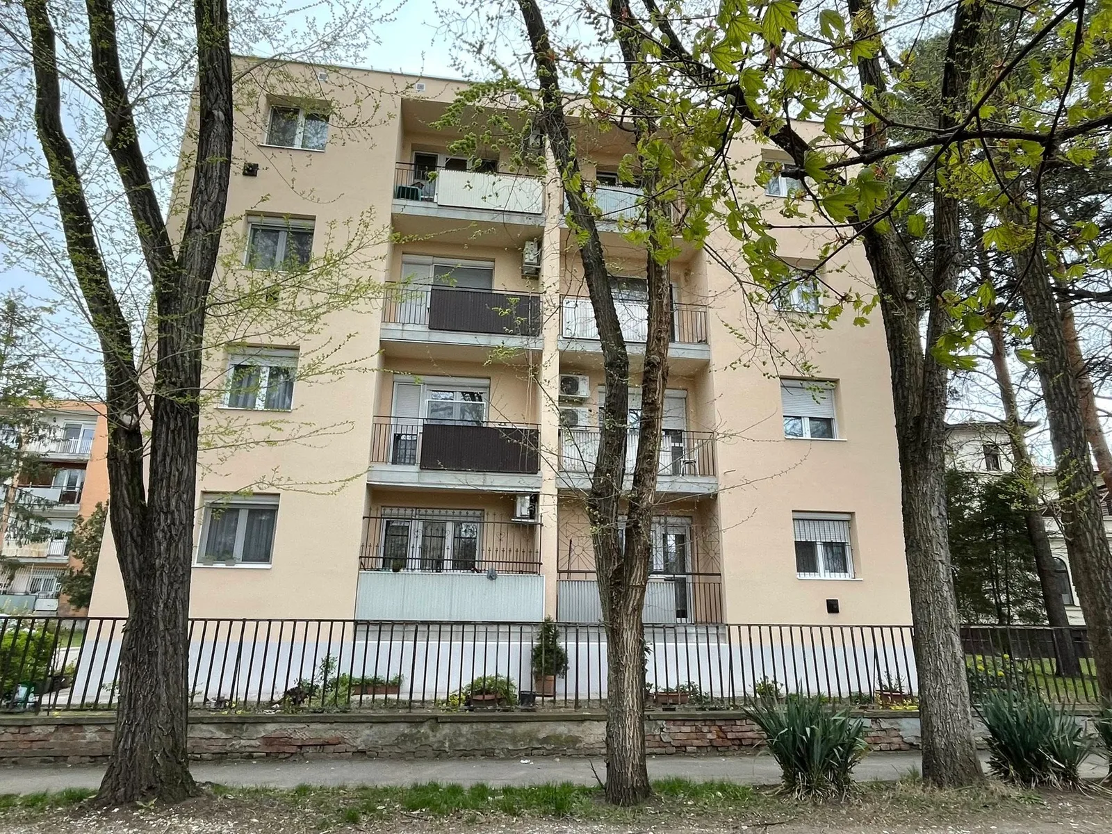 Társasház fákkal övezett homlokzata a Csanak József utcában.